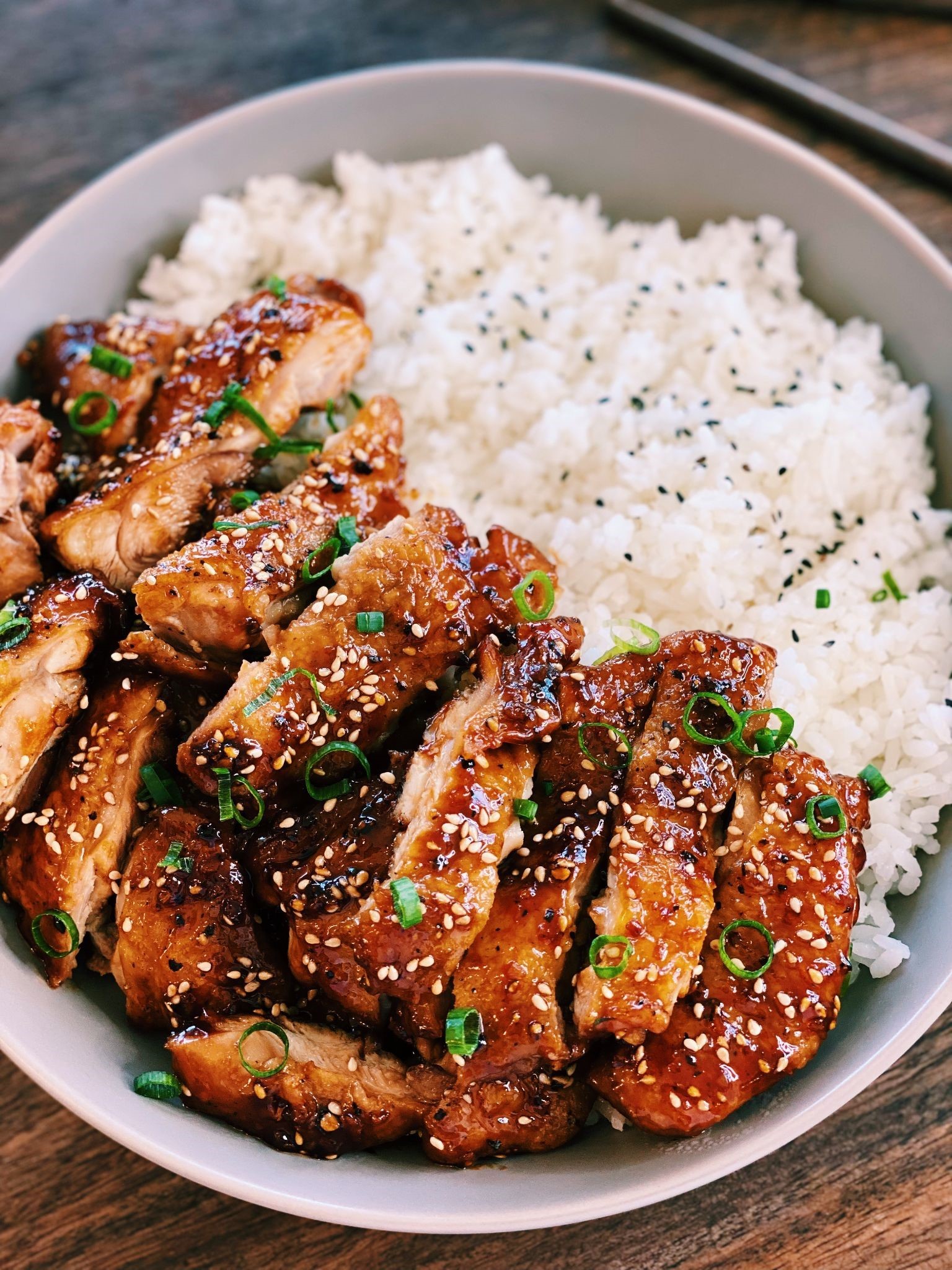chicken and rice garnished with sesame seeds and green onions.